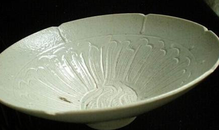 在北宋的早期与中晚期，定窑瓷器以什么装饰而深受喜爱？